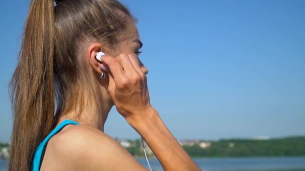 Frau läuft morgens mit Kopfhörern im Park — Stockvideo