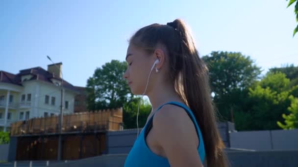 Une fille qui court et écoute de la musique dans un parc. Mode de vie sain des femmes contemporaines, perte de poids et maintien de la forme — Video