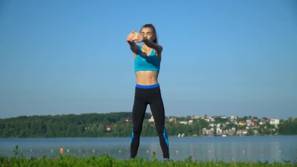 Νεαρό κορίτσι κάνει πρωινές ασκήσεις στο πάρκο, δραστηριότητα γυμναστικής, ευεξία — Αρχείο Βίντεο
