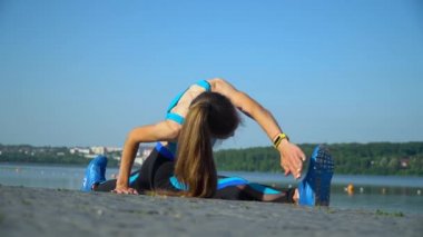 Kız gölün yanında bir ipin üzerinde oturuyor.