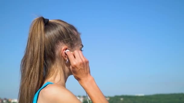 Young girl running with headphones at the park in the morning — Stock Video