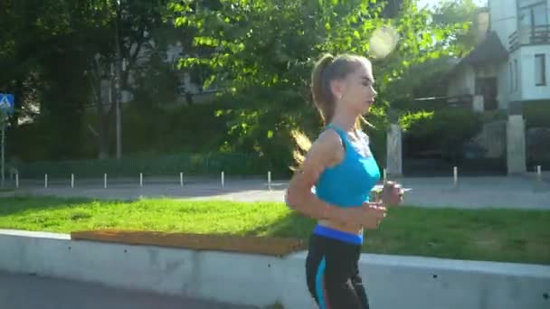 Mädchen läuft und hört Musik in einem Park. gesunder Lebensstil zeitgenössischer Frauen, Gewichtsverlust und Fitness — Stockvideo