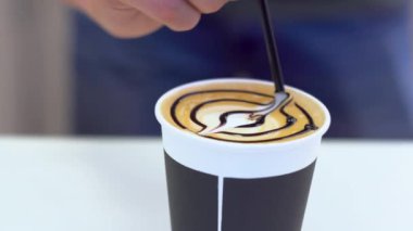 Barista bir kahve ağı resmi yapar. Latte sanat Web