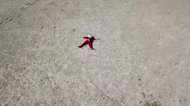 Babbo Natale si trova sulla spiaggia di sabbia. Vista dall'alto. Macchina fotografica che si muove dalle gambe alla testa di Babbo Natale . — Video Stock