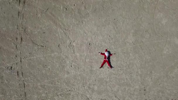 Le Père Noël est allongé sur la plage de sable. Vue du dessus — Video