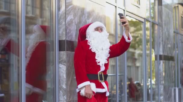 Papai Noel tirar uma selfie contra um fundo de parede e mostrando o gesto "paz " — Vídeo de Stock