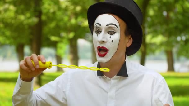 Szórakoztató pantomim fújás szappanbuborékok a szabadban — Stock videók