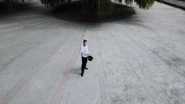 Vista aérea de mímica engraçada joga seu chapéu ao ar livre — Vídeo de Stock