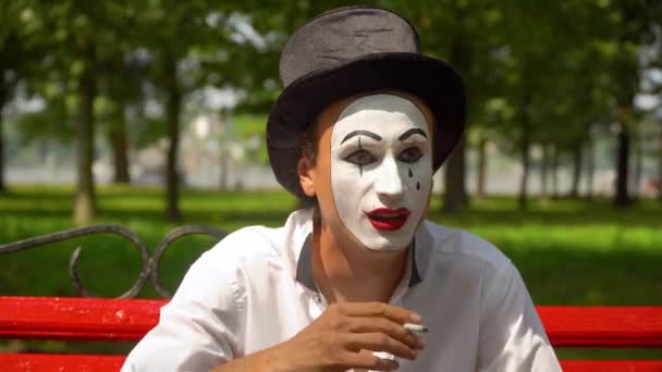 Close-up of a mime smokes outdoors. Bad habits — Stock Video