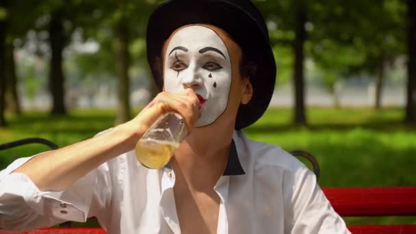 Close-up of a mime drinks alcohol outdoors. Bad habits — Stock Video