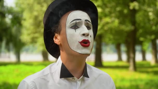 Mime in a black hat smokes outdoors. Bad habits — Stock Video