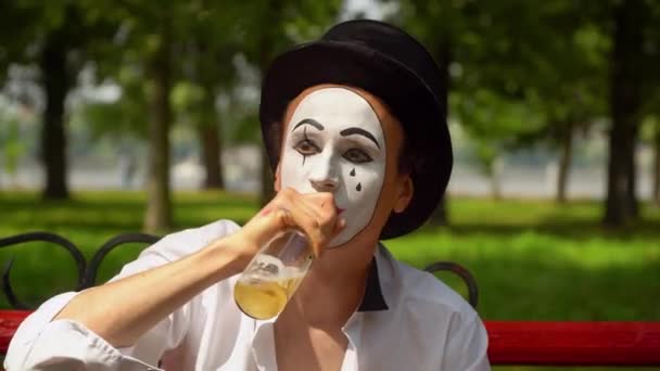 Close-up of a mime drinks alcohol outdoors. Bad habits — Stock Video
