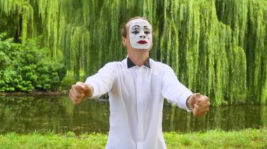 Parktaki pandomim pandomim gösterisi. Pandomimci adam araba taklidi yapıyor.