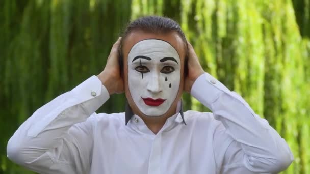 Mime on the park shows pantomime. Mime closes her ears with hands — Stock Video