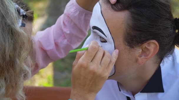 Menina pintar sobrancelhas para jovem mímica com lápis preto — Vídeo de Stock