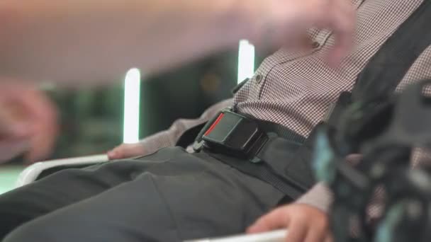 Femme attache la ceinture de sécurité sur la configuration de la réalité virtuelle. Vue d'un garçon passager aux cheveux roux — Video