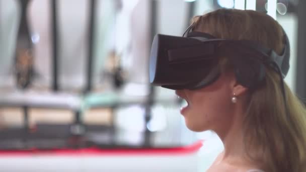 Flicka bär virtuella verklighets glasögon uttrycker överraskning och säger "Wow" — Stockvideo