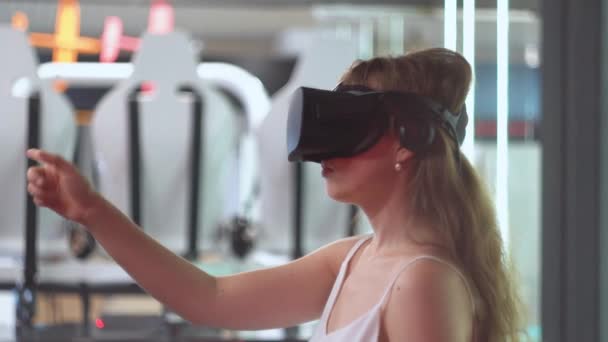 Chica joven en gafas de realidad virtual voltea páginas virtuales horizontalmente — Vídeos de Stock