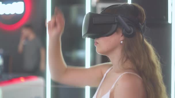 Menina em óculos de realidade virtual detém uma linha imaginária na forma de uma hipérbole — Vídeo de Stock