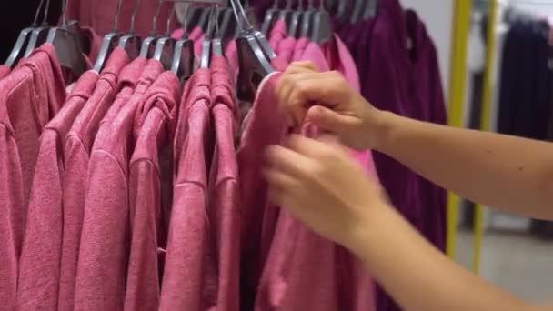 Una donna sceglie stoffe lavorate a maglia nel negozio. Vista ravvicinata delle mani — Video Stock