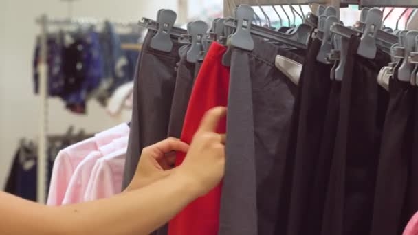 La mujer elige leggings de punto en la tienda. Vista de cerca de las manos — Vídeos de Stock