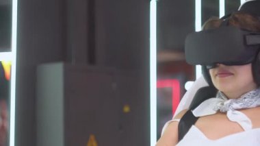 Yetişkin bir kız ya da kadın sanal gerçeklik gözlükleriyle etrafa bakıyor.