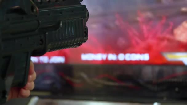 Barnet håller fjärrkontrollen till spelet virtuell verklighet i form av en pistol och på bakgrunden av skärmen som skildrar spelet — Stockvideo