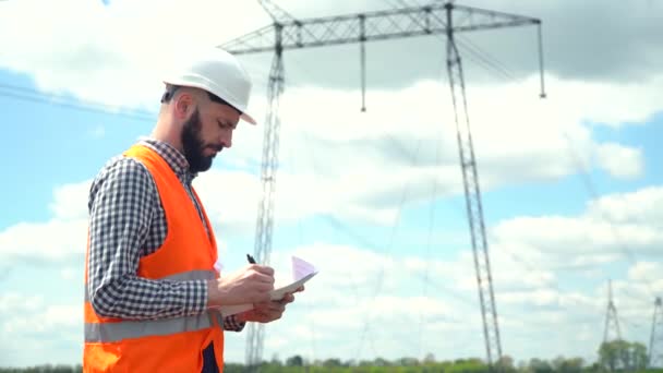 Ingenieur werkt in de buurt van transmissielijnen — Stockvideo