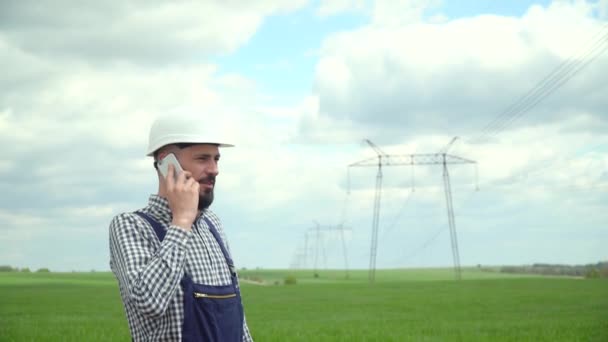 送電線の近くで働いてる技術者。電話による不完全な電気技術者のスコアリング部下 — ストック動画