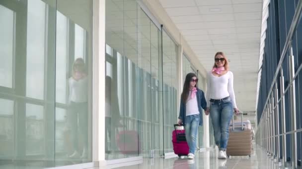 Deutschland, Frankfurt, März 2020: Passagiere mit Koffern auf dem Terminal-Flughafen. Frau und kleines Mädchen mit Gepäck auf dem Flughafen — Stockvideo