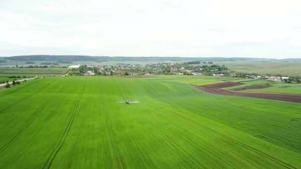 Воздушный обзор распыления трактора на поле с помощью опрыскивателя, гербицидов и пестицидов — стоковое видео