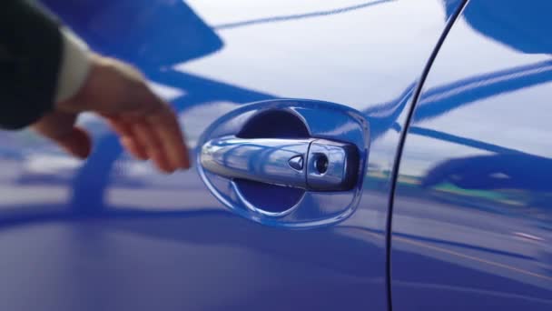 Close-up of blue car door handle opened by male hand. Car dealership, car business — Stock Video