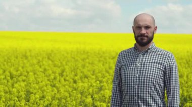 Genç sakallı çiftçi kolza tohumu filizleniyor.