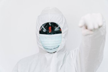 Koruyucu giysili ve siyah maskeli bir virüs uzmanı portresi.