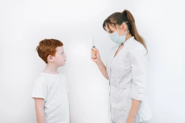 Médico inyectando a un niño con una vacuna en una pequeña jeringa hipodérmica desechable, primer plano del brazo y la aguja del niño —  Fotos de Stock