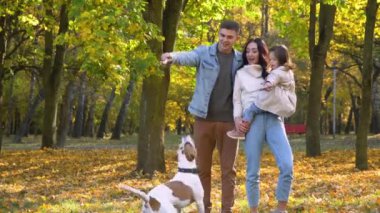 Sonbahar parkında köpekli mutlu bir aile. Düş