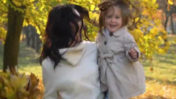 Счастливая мать с маленькой дочерью в осеннем парке. Падение — стоковое видео