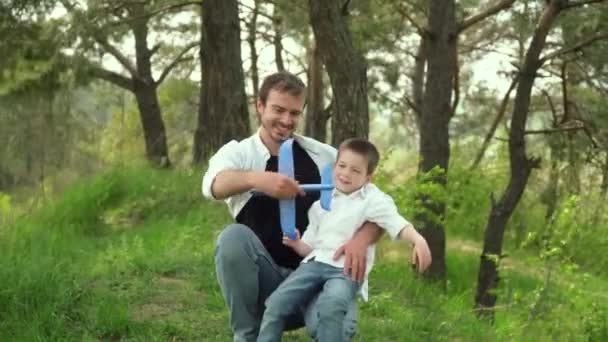 Vater und Sohn spielen am Wochenende mit dem Spielzeugflugzeug im Park. Glückliche Kindheit. Glücklicher Vatertag — Stockvideo