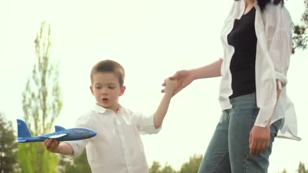 Madre e hijo juegan en un avión de juguete en el parque el fin de semana. Feliz infancia. Feliz día de las madres — Vídeo de stock