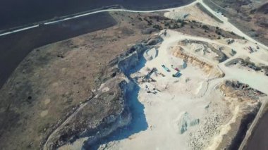 Kazıcı ve kamyon kum ocağında çalışıyor. Bir kamyona kum yükleme görüntüsü