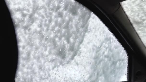 Autowasserij zelfbediening. Een man wast de auto met hogedrukapparatuur. Binnenkant van de auto — Stockvideo