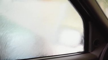 Bir adam makineyi yüksek basınçlı ekipmanla yıkar. Yüksek basınçlı bir su püskürtüsü arabanın kirini temizler. - Evet. Arabanın iç manzarası.