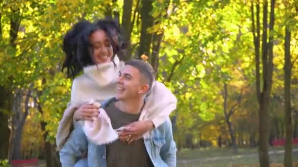 Famille joyeuse et riante. Couple heureux s'amuser dans le parc d'automne — Video