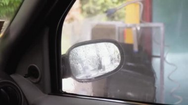 Bir adam makineyi yüksek basınçlı ekipmanla yıkar. Yüksek basınçlı bir su püskürtüsü arabanın kirini temizler. - Evet. Arabanın iç manzarası.