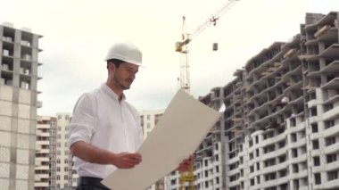 Şablon planıyla inşaat alanının mimarı veya mühendisi çalışıyor, geziniyor