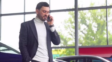 Araba galerisi müdürü araba satmayı kabul etti. Satıcı aktarımın detaylarını telefonla tartışır