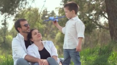Baba, anne ve oğul hafta sonu parkta oyuncak uçakla oynuyorlar. Ortak bir aile sağlıklı bir yaşam tarzı ister. Mutluluk kavramı