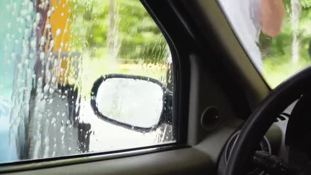 Auto-servicio de lavado de autos. Un hombre lava el coche con equipo de alta presión. Vista interior del coche — Vídeos de Stock