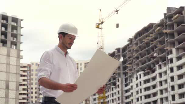 Архитектор или инженер работающий, просматривающий строительный проект строительной площадки с чертежным планом — стоковое видео