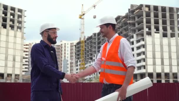 Architecte ou ingénieur travaillant, projet de construction de navigation du chantier avec plan directeur. Les constructeurs se serrent la main. Concept de construction de bâtiments — Video